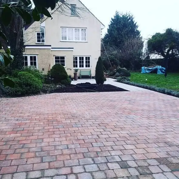 Sandstone patio with curved brick-edged steps at a new-build home