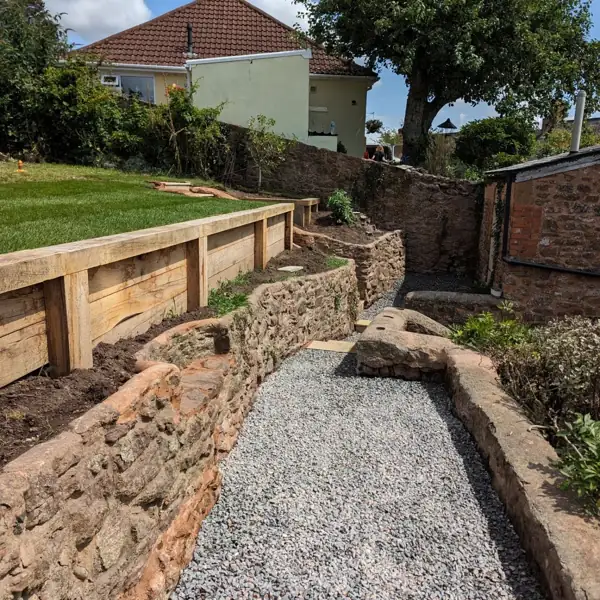 Sandstone steps flanked by red stone walling