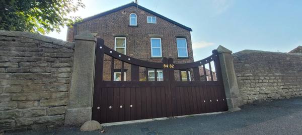 Bespoke timber driveway gates hung between stone pillars